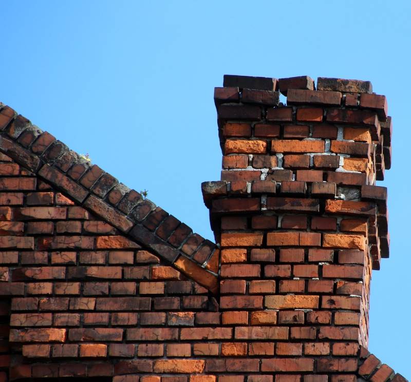 Damaged chimney on an Auburn Hills home showing cracks and missing mortar